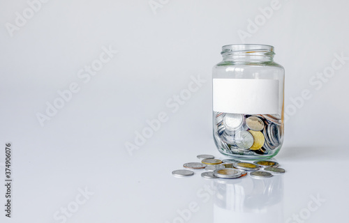 coins (Thai money) on white table with over light and soft-focus in the background