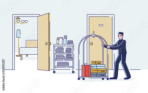 Bellboy carrying luggage on cart. Hotel porter in uniform with visitor baggage