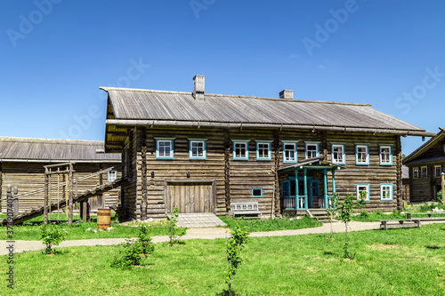 Wooden house on green grass with blue sky
