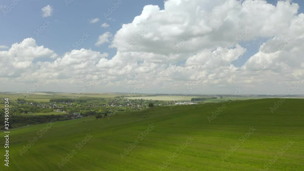 Scenic aerial panoramic view of idyllic rolling hills spring landscape in with lush green mountain pastures in evening light at sunset Scenic aerial panoramic view of idyllic rolling hills spring landscape in with lush green mountain pastures in evening light at sunset