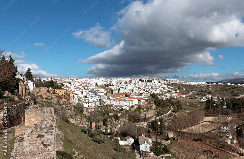 Ronda, Andalusia, Spain: a dark cloud hovers over the old town on a sunny winter day