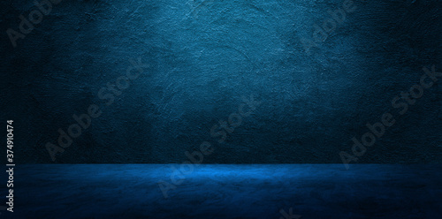 Empty space studio room of Plaster concrete wall grunge texture background with blue lighting effect for product showing.