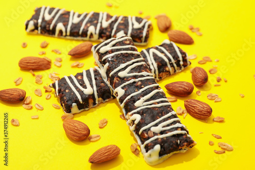 Tasty granola bars on yellow background, close up