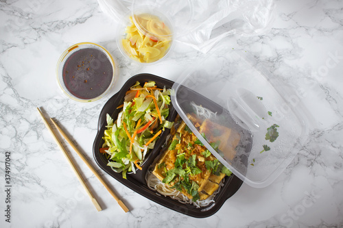 Vietnamese bun chay noodle salad take out box on white marble surface photo