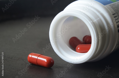 pill spilling out of pill bottle, yellow and red pills photo