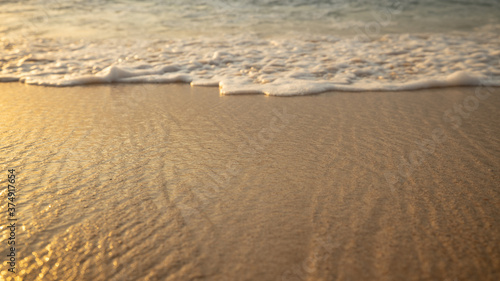 Scenic seascape. Milky foam waves at the beach. Sunset time. Waterscape for background. Selected soft art focus. Sunlight reflection on the water and sand. Balangan beach  Bali  Indonesia