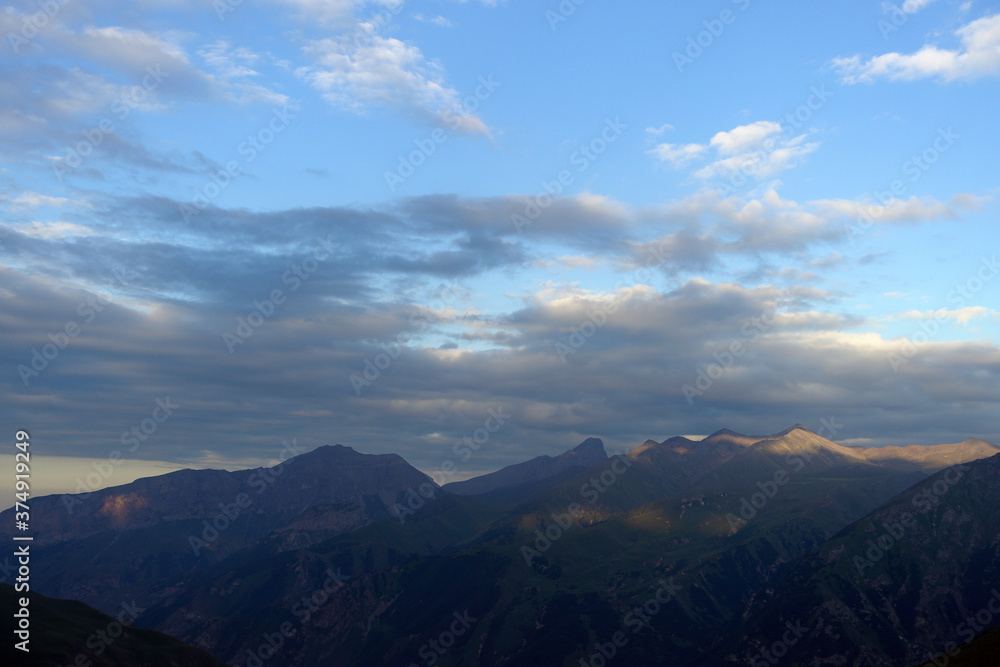 Silhouettes of mountains in the evening haze. Mountain ranges at sunset. Dusk.