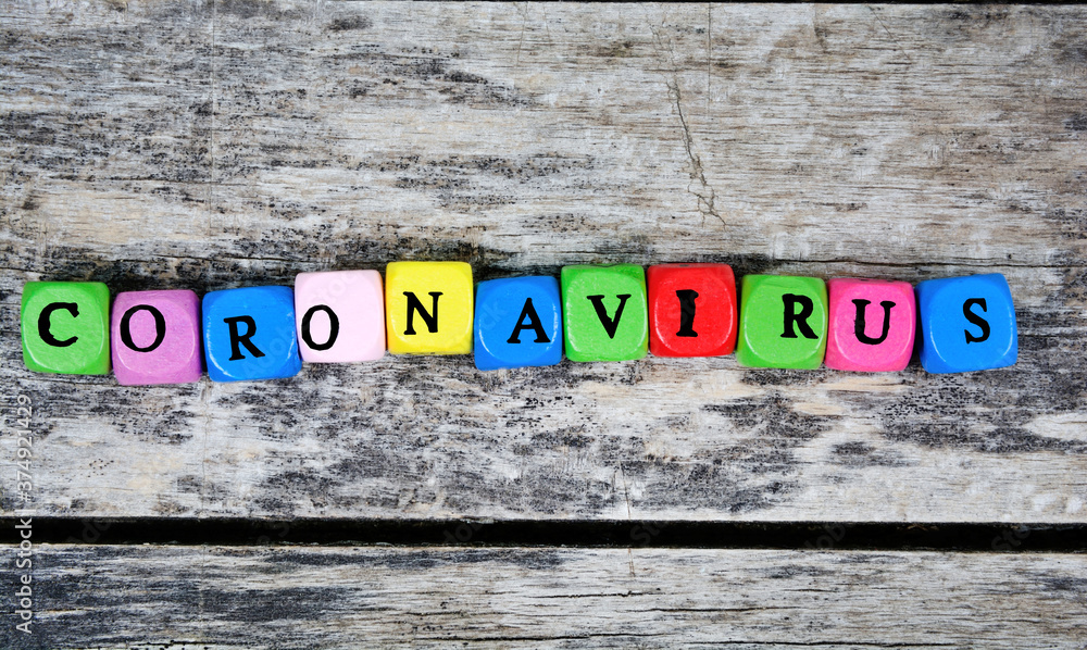 Fototapeta premium Coronavirus word on a wooden table