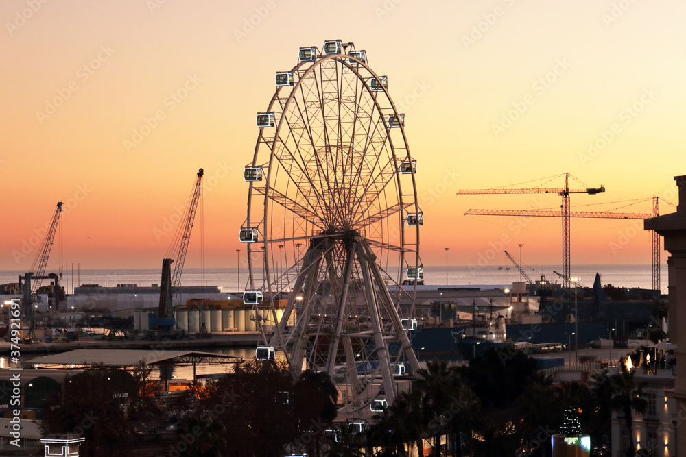 Malaga, Spain: ferris wheel at sunset near the harbour