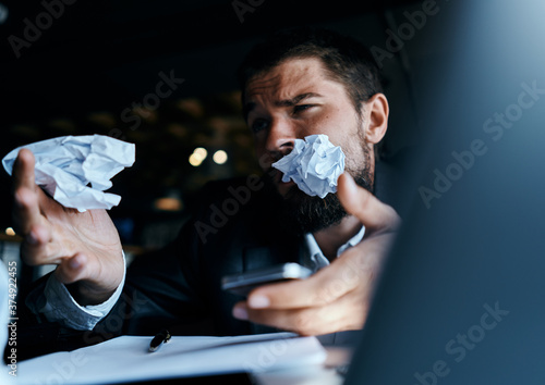business man sitting at table in front of laptop crumpled paper lifestyle executive job technology
