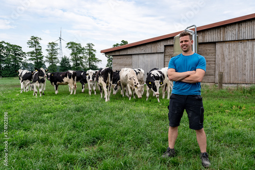 Begeisterter, junger Rinderzüchter  vor seiner Rinderherde. photo