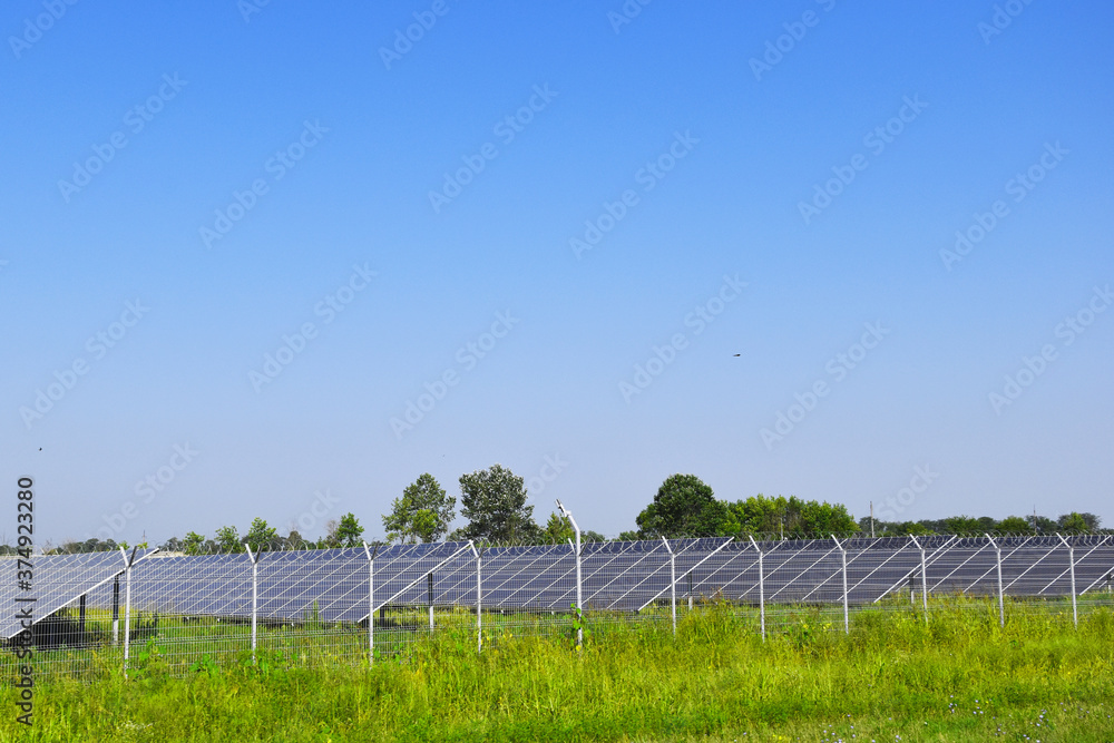 Row of solar panels, photovoltaic solar panel on a blue sky background. Alternative solar energy concept. Row of solar panels, photovoltaic solar panel on a blue sky background. Alternative solar energy concept.
