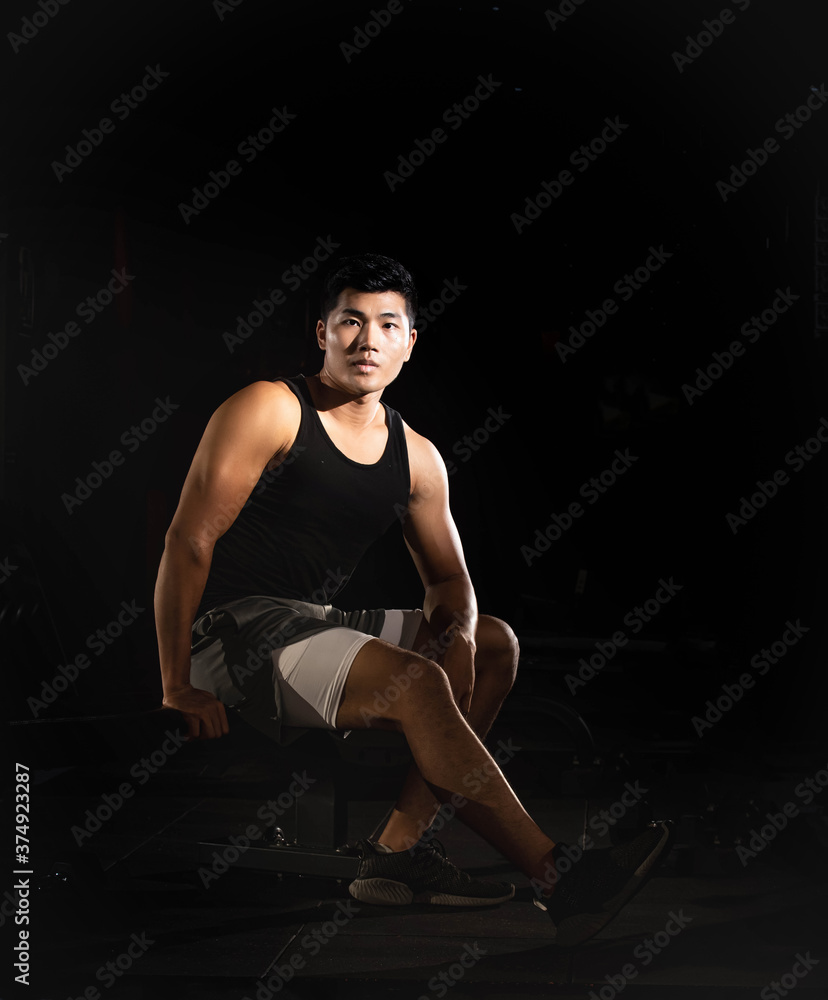 Handsome man sitting and posing,show fit and firm of muscle