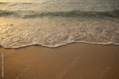 Scenic seascape. Milky foam waves at the beach. Sunset time. Waterscape for background. Selected soft art focus. Sunlight reflection on the water and sand. Balangan beach, Bali, Indonesia