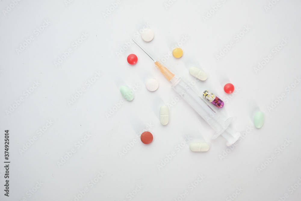 syringe and pills on white background, top view 