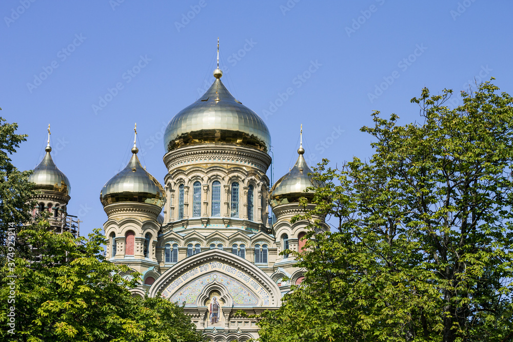 Russian Orthodox Church in Liepaja in a sunny summer day, green trees at the front