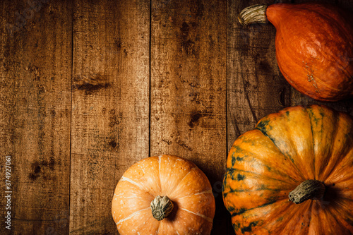  Autumn pumpkins on a wooden rustic background, top view, free space for text