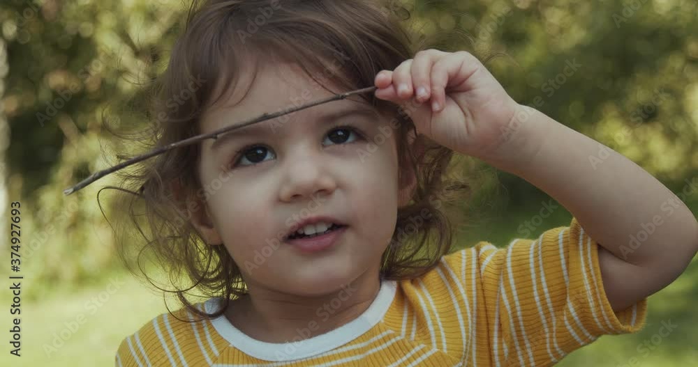 Cute toddler baby girl enjoying the park in summer. Real life footage. Shot in 4K.