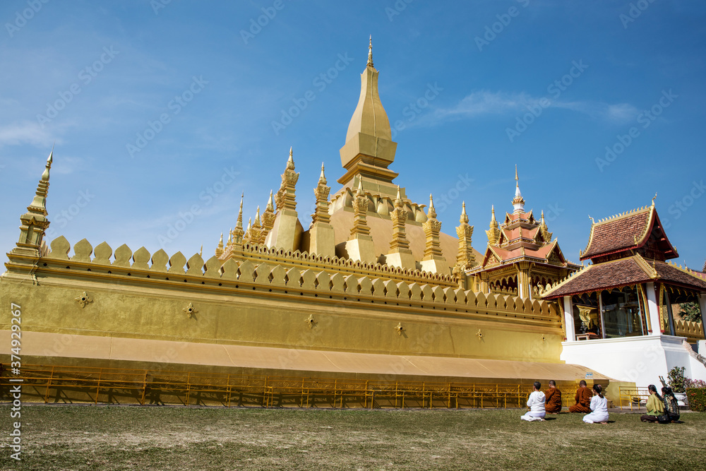 Pilgrims praying at the great stupa in Vientiane, Laos.