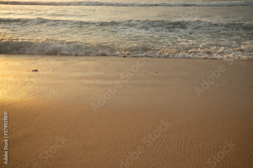 Scenic seascape. Milky foam waves at the beach. Sunset time. Waterscape for background. Selected soft art focus. Sunlight reflection on the water and sand. Balangan beach  Bali  Indonesia