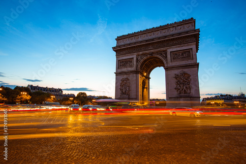The night view of triumphal arch and traffic in Paris, France. © Zimu
