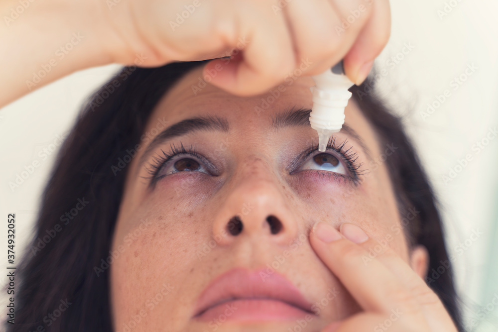 woman using eye drop, woman dropping eye lubricant to treat dry eye or