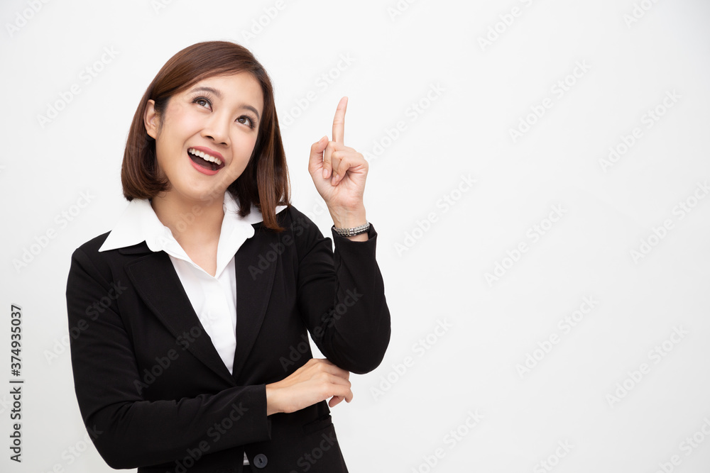 Smiling asian business woman pointing up isolated over white background Smiling asian business woman pointing up isolated over white background