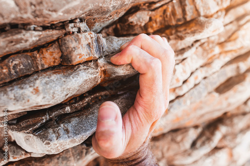 фотографія Strong male fingers cling to a rock ledge - close-up rock climbing