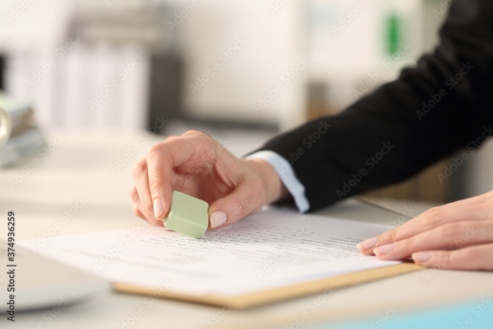 Executive hands erasing with rubber sits at office Executive hands erasing with rubber sits at office