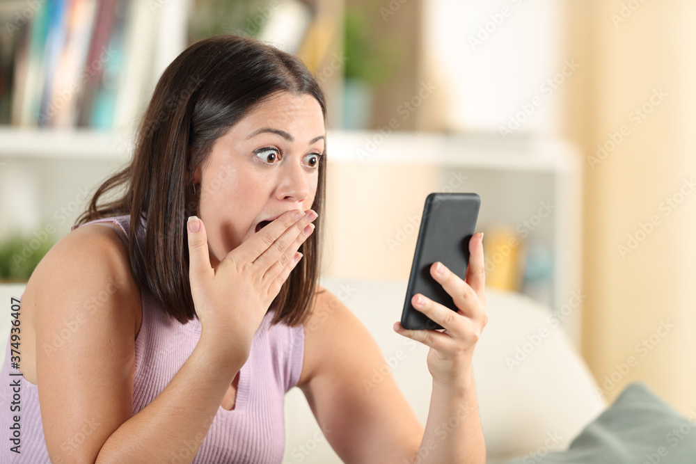 Surprised woman checking phone finding amazing content Surprised woman checking phone finding amazing content