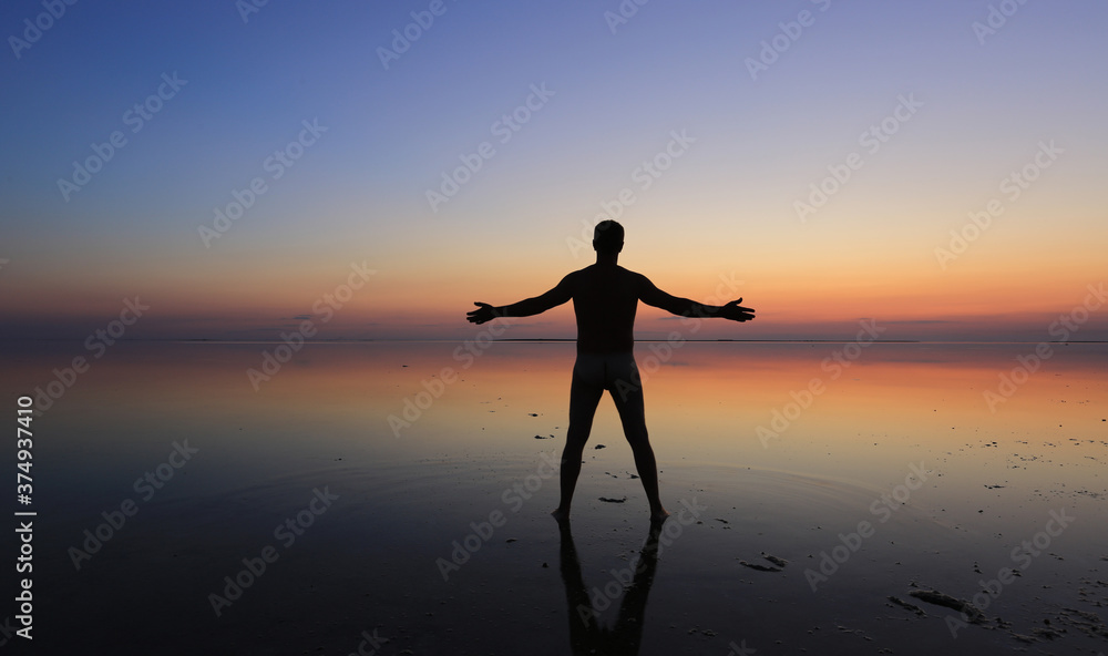 man stands in the water on the coast
