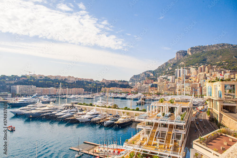 The coastal view of the port and boats in Monaco, on a sunny day.