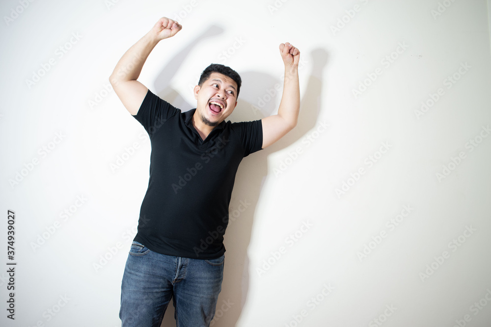 Portrait of a young Asian man Wear a black polo shirt
Making a happy expression
In a white background