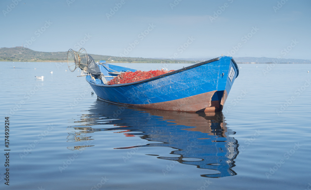 Fototapeta premium Boat in the water. Fishing boat in the calm waters of the pond of santa caterina in southern sardinia