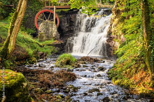 Wallpaper Mural Vintage red waterwheel with waterfall in autumn colours in Glenariff Forest Park