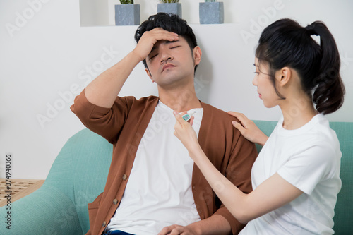 The man feeling uncomfortable. The woman taking care of him at home.