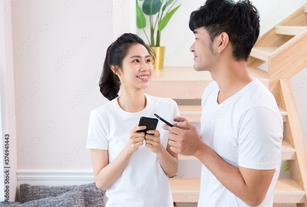 Young cheerful guy and woman talking and laughing while having fun together while using smartphones. Young cheerful guy and woman talking and laughing while having fun together while using smartphones.