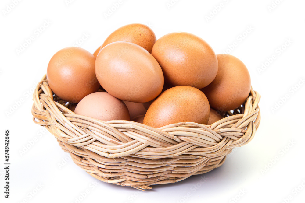 Eggs in basket on white background. Brown eggs in a wicker basket on white background. Eggs in basket on white background. Brown eggs in a wicker basket on white background.