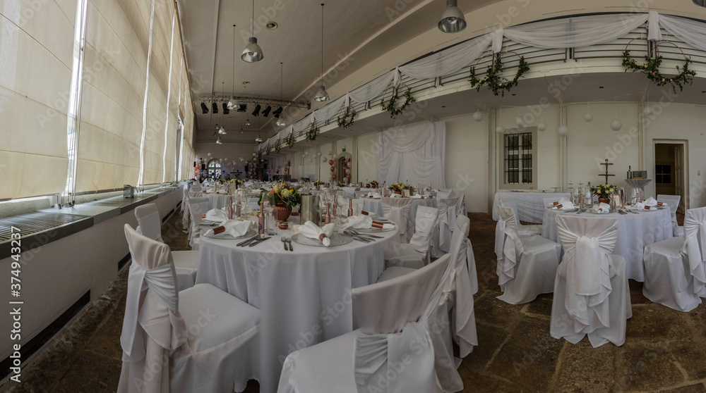 many tables and chairs at a white wedding panorama