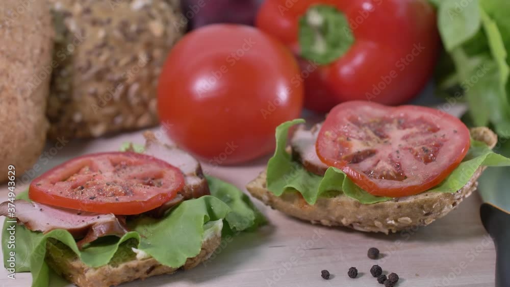 Preparing sandwich on breakfast table full of vegtables. Preparing sandwich on breakfast table full of vegtables.