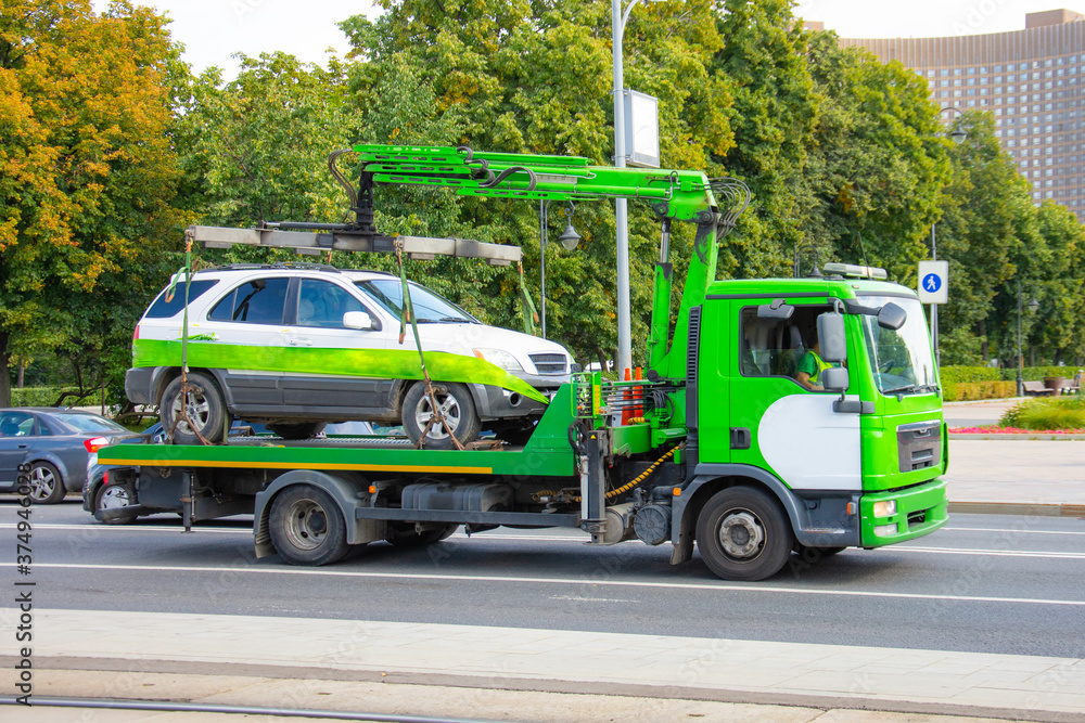 Towing of vehicle on forklift truck. Tow truck with equipped suspension mechanism crane evacuation and transportation to a fine parking lot.