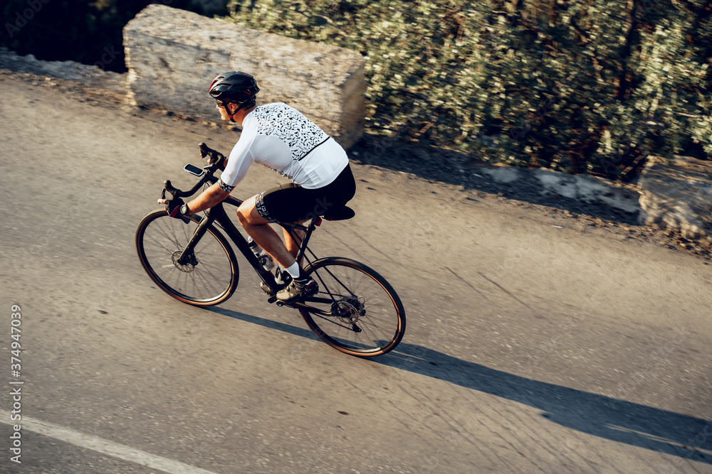 Professional cyclist on a mountain road at sunrise