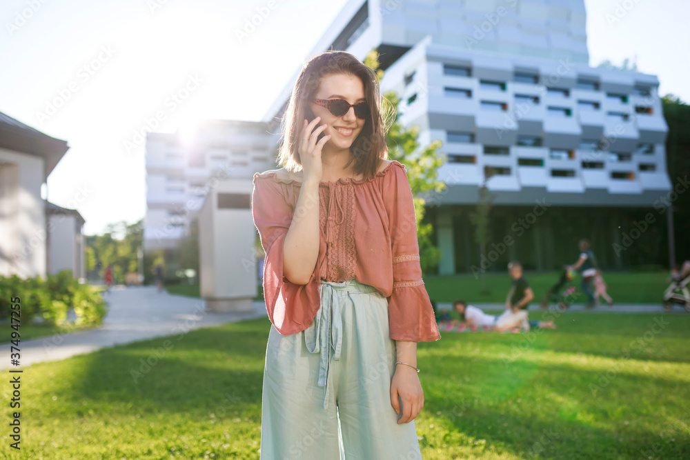 Portrait of a smiling beautiful girl with glasses talking on the Portrait of a smiling beautiful girl with glasses talking on the