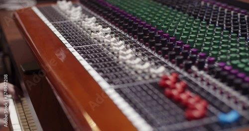 Man in a control room of a recording studio moving a fader with a Toft console / Professional recording studio / 4K at 60fps (slowmotion) / Professional audio vives photo