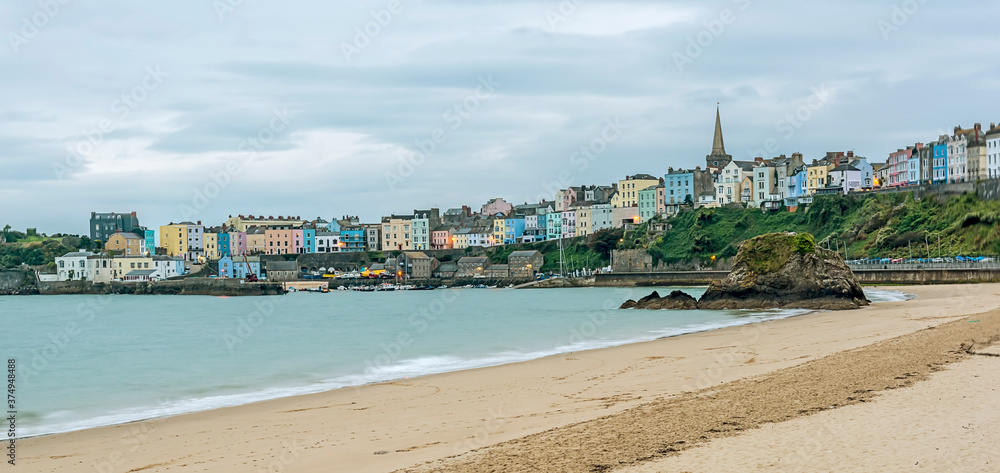 The multi-coloured Georgian town of Tenby and Goscar Rock viewed from the North Beach at sunrise in Autumn