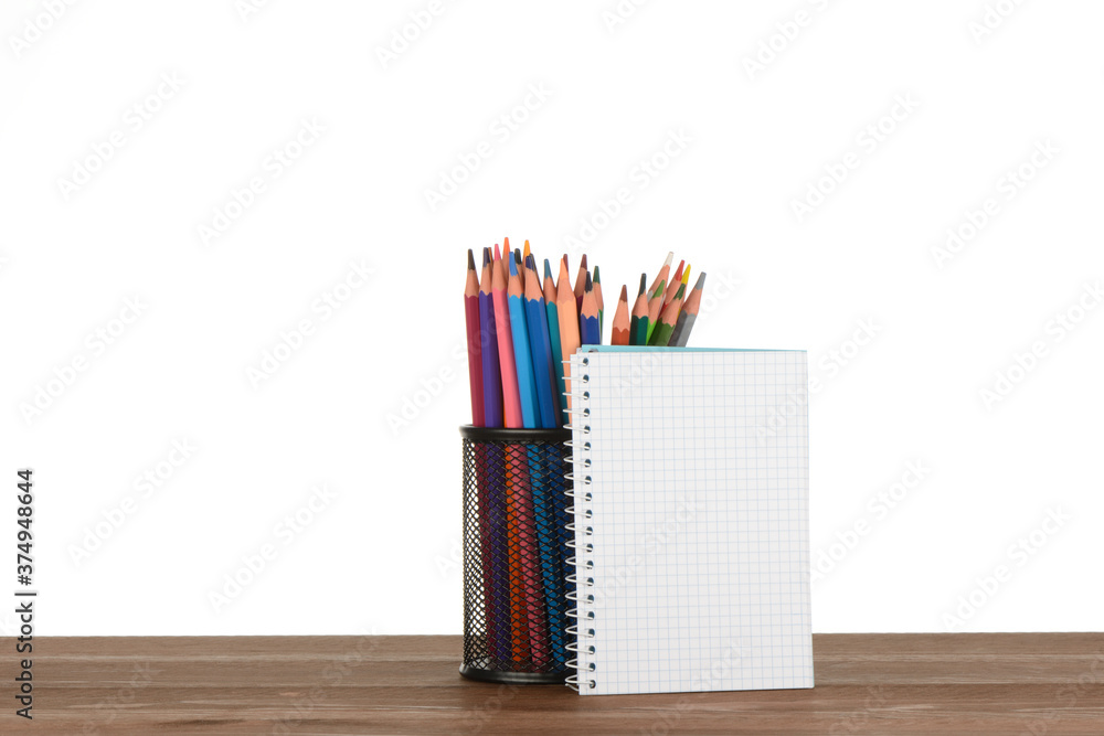 Fototapeta premium Bote lleno de lapiceros de colores en la mesa y un cuaderno