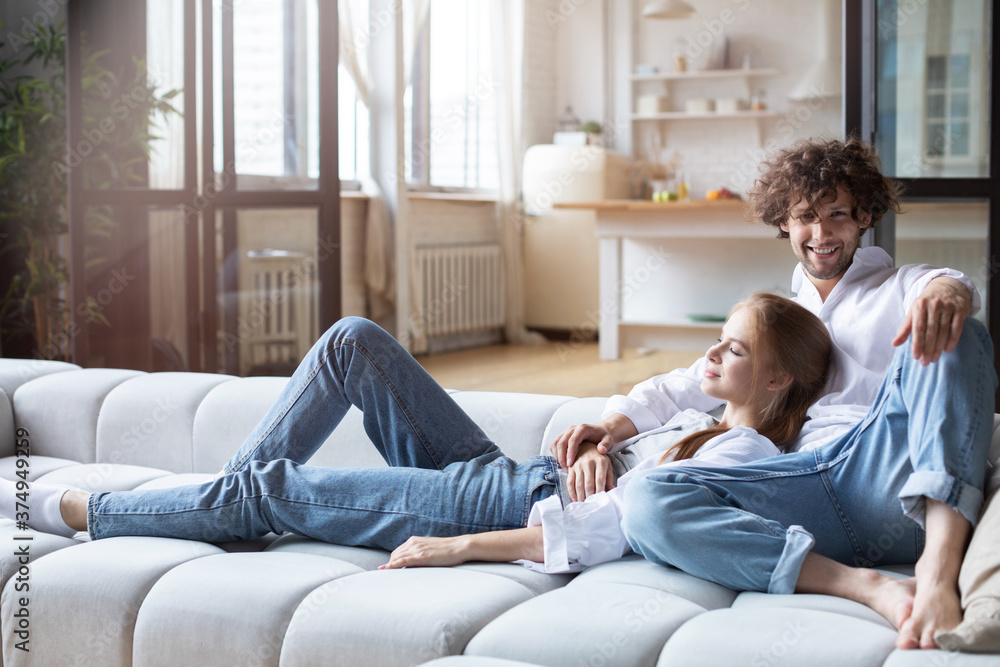 Couple relaxing on a couch at home.