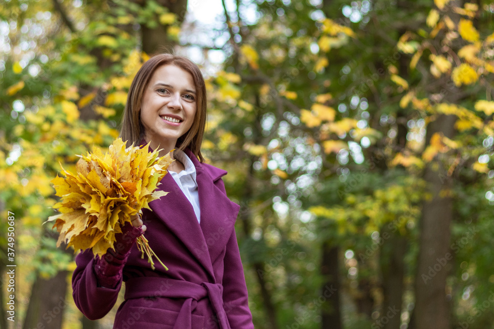 Portrait of young smiling woman while walking in autumn park. Portrait of young smiling woman while walking in autumn park.
