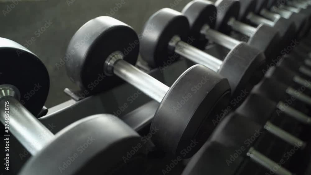 dolly shot, dumbbells are neatly arranged in the gym
dolly shot, dumbbells are neatly arranged in the gym