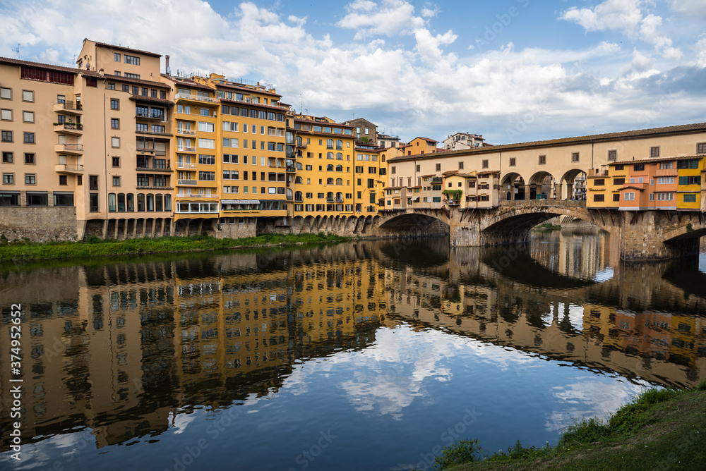 FLORENCE / ITALY - MAY 6 2017: Ponte Vecchio and its surroundings reflected in the Arno river.